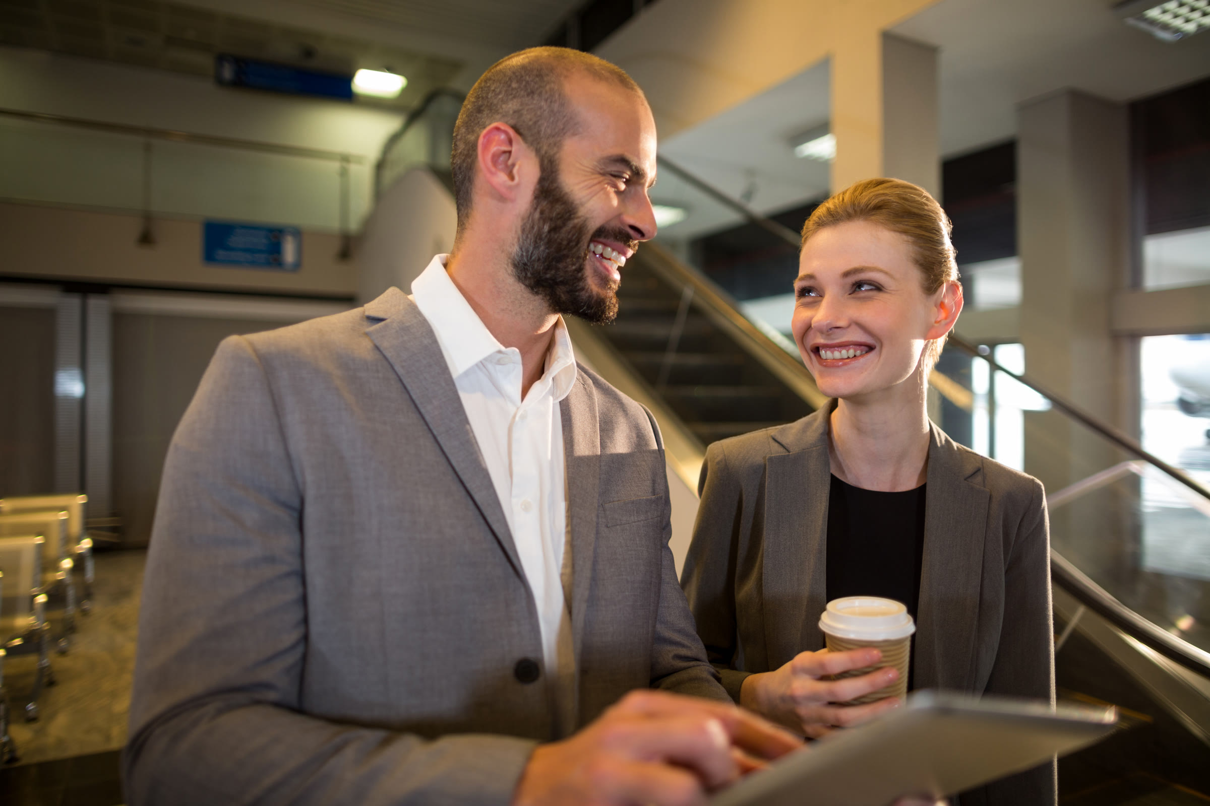 Two business professionals discussing strategy over a tablet in a modern office